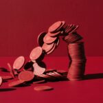 Meja permainan kartu baccarat dengan tumpukan chip di atas taplak hijau